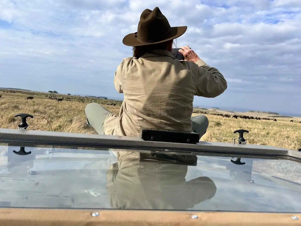 Tourist photographing wildlife during guided safari in Kenya